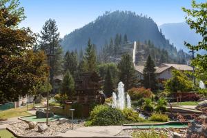 a fountain in a garden with a mountain in the background at Tumwater Vista Retreat, Unit 903 in Leavenworth