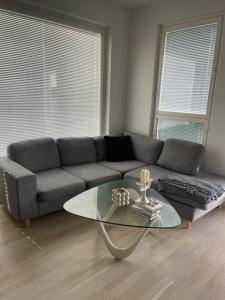 a living room with a couch and a glass table at Location courte durée, jolie appartement lumineux in Vantaa