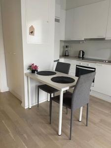 a kitchen with a table and chairs in a kitchen at Location courte durée, jolie appartement lumineux in Vantaa