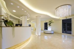 a lobby with columns and a chandelier at Hotel Riviera in Milano Marittima