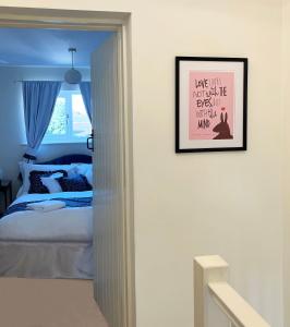 een slaapkamer met een bed en een ingelijste foto aan de muur bij Traditional 2 bedroom Cottage in Stratford-upon-Avon