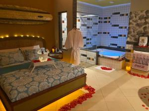 1 dormitorio con 1 cama grande y bañera en KANKUN MOTEL E POUSADA -Adult only en Sorocaba