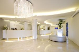 a lobby with a waiting area with a chandelier at Hotel Riviera in Milano Marittima