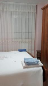 una cama con dos toallas delante de una ventana en La casa nel Borgo, en Bella