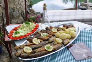 a tray of sausages and vegetables on a table at Karuc Apartments in Karuč