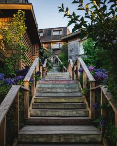 uma escada que leva a uma casa com flores roxas em Hotel Agua Nativa em Puerto Varas