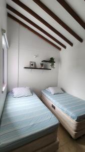 サンタ・フェ・デ・アンティオキアにあるApartasol Ciudadela Santafe - Santa Fe de Antioquiaの部屋に並んで置かれた2つのベッド +73枚の写真