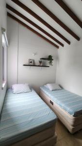 two beds sitting next to each other in a room at Apartasol Ciudadela Santafe - Santa Fe de Antioquia in Santa Fe de Antioquia