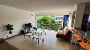 サンタ・フェ・デ・アンティオキアにあるApartasol Ciudadela Santafe - Santa Fe de Antioquiaのテーブルとソファと窓のあるリビングルーム