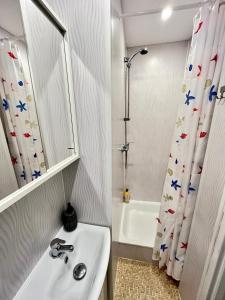 baño con lavabo y cortina de ducha en Luff Gdynia Morska, en Gdynia