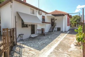 a white house with a porch and a staircase at SOCRATES Ethnic and traditional Home in Kalabaka