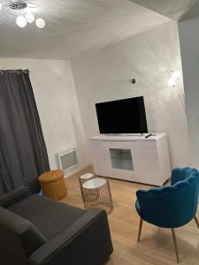 uma sala de estar com um sofá e uma televisão de ecrã plano em Appartement proche de paris em Saint-Cloud