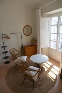 ein Wohnzimmer mit einem Tisch, Stühlen und einem Fenster in der Unterkunft Can Set in Cadaqués