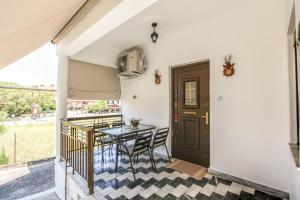 een balkon met een tafel en stoelen en een deur bij SOCRATES Ethnic and traditional Home in Kalabaka