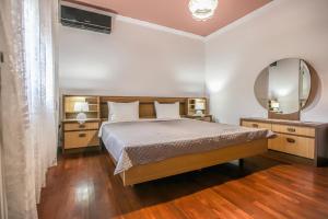 a bedroom with a large bed and a mirror at SOCRATES Ethnic and traditional Home in Kalabaka