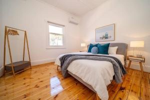 a bedroom with a large bed with blue pillows at Kairos in Keswick at Keswick in Keswick