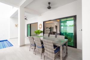 a dining room with a glass table and chairs at Koh Chang Luxury Pool Villas in Ko Chang