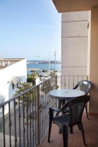 a table and chair on a balcony with a view of the ocean at Apartamentos Port Cambrils in Cambrils