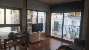 a living room with large windows and a flat screen tv at Apartamentos Port Cambrils in Cambrils