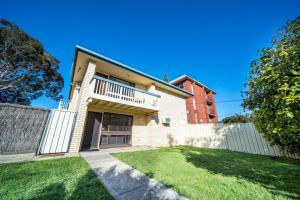 a house with a white fence and a yard at Serenity by the Sea Grange in Grange