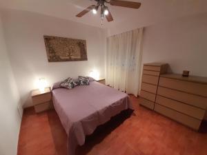 um quarto com uma cama e uma ventoinha de tecto em CALZADA Homes em Almeria