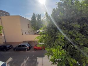 dois carros estacionados num parque de estacionamento ao lado de um edifício em CALZADA Homes em Almeria