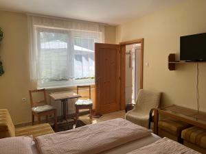Un dormitorio con una cama y una mesa y sillas. en Privát Pekný dvor, en Rajecké Teplice