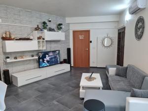 a living room with a couch and a tv at Appartamento del Li-Lioni di Teranga 2 in Platamona