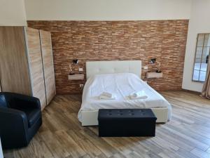 a bedroom with a white bed and a brick wall at Appartamento del Li-Lioni di Teranga 2 in Platamona