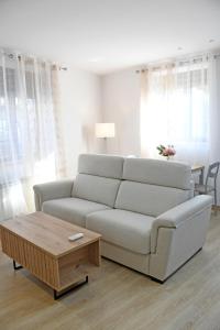 uma sala de estar com um sofá branco e uma mesa de centro em Edulis 2 em Arenas de San Pedro