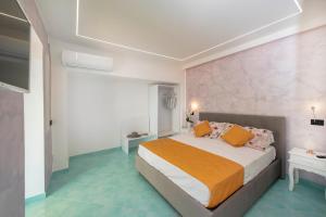 een slaapkamer met een groot bed met oranje en witte kussens bij La Maison Raffaele & Rita in Amalfi