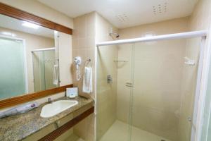 a bathroom with a sink and a glass shower at Resort Costa Dos Coqueiros in Imbassai