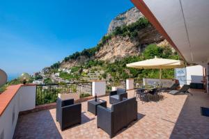 een terras met een tafel, stoelen en een parasol bij La Maison Raffaele & Rita in Amalfi