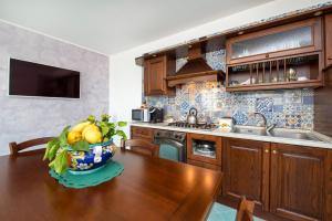 een keuken met een houten tafel met een schaal fruit bij La Maison Raffaele & Rita in Amalfi