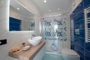 een badkamer met een wastafel, een toilet en een douche bij La Maison Raffaele & Rita in Amalfi