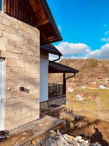 ein Gebäude mit einem Balkon mit Blick auf ein Feld in der Unterkunft VILA MASLACAK in Popovići