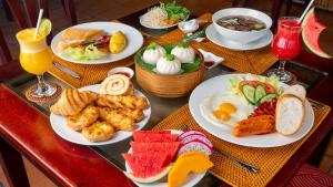 - une table avec des assiettes de produits pour le petit-déjeuner et des boissons dans l'établissement Bamboo Village Beach Resort & Spa, à Mui Ne