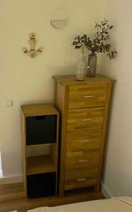 a wooden dresser with a plant on top of it at Kleines Glück Grömitz (ehemals Deichperle) in Grömitz