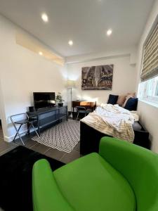 a living room with green chairs and a bed at Modern flat in central Egham by Windsor Castle, Staines-Upon-Thames and Heathrow Airport in Egham