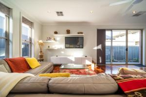 a living room with a couch and a tv at The Arlington - Easy Stay near Entertainment & CBD in Bowden