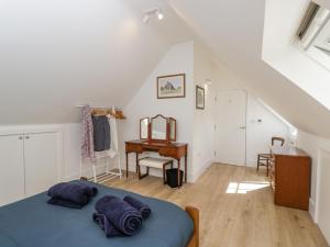 1 dormitorio con cama y escritorio en The Old Stable, en Witney