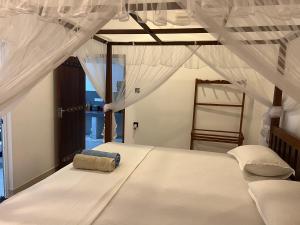 ein Schlafzimmer mit einem weißen Bett mit Baldachin in der Unterkunft Awesome Guest Mirissa in Mirissa