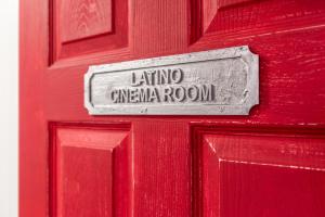 una puerta roja con un cartel que lee la sala de cine latino en Baila Casa en Nottingham