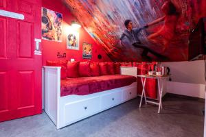 um quarto vermelho com uma cama com um quadro na parede em Baila Casa em Nottingham