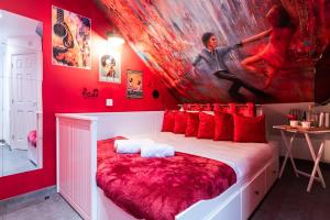 a red bedroom with a large painting on the wall at Baila Casa in Nottingham
