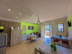cocina y sala de estar con paredes verdes y mesa en B&B Afrodite en Leporano
