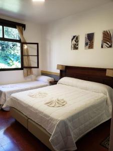 1 dormitorio con 2 camas y ventana en Hotel Suizo en Puerto Rico