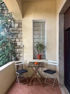 a patio with two chairs and a table and a window at Casetta dei fiori in Livorno