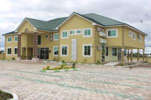 a large yellow building on a brick road at Dellagio Hotel in Wa