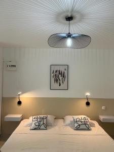 een slaapkamer met een groot bed en een plafond bij Superbe studio avec Piscine, au coeur de la Marina! Village Soleil ! in Le Gosier